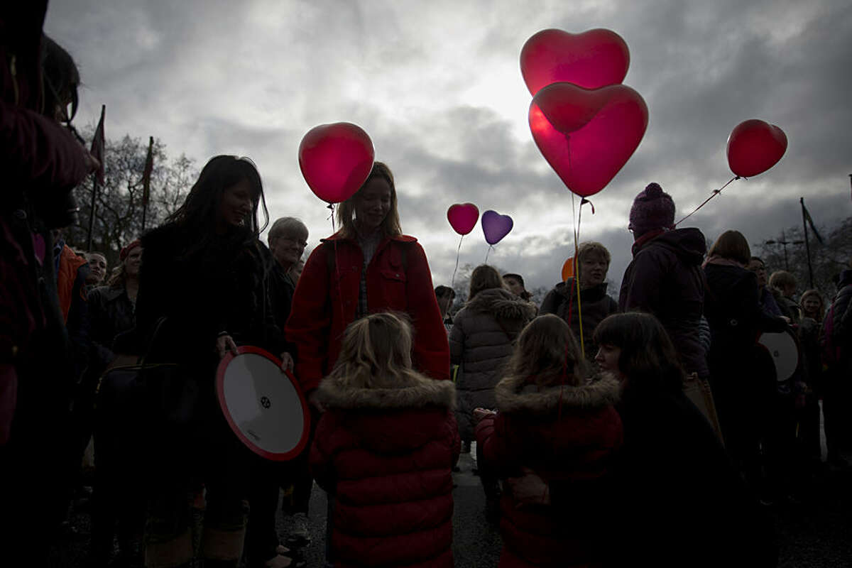 Women and girls hold love heart shaped balloons during a day of action event with a theme of love revolution and a focus on healthy relationships organized by the One Billion Rising movement at Marble Arch in London, on Valentine's Day, Saturday, Feb. 14, 2015. One Billion Rising is so named to give awareness to the statistic that one in three women in the world will be raped or beaten in their lifetime which equates to one billion women. (AP Photo/Matt Dunham)