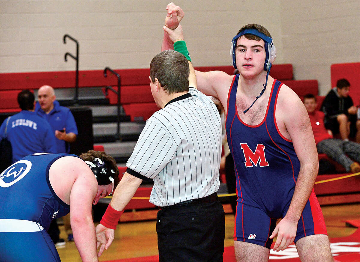 Hour photo / Erik Trautmann Local wrestlers compete in the FCIAC Championship meet at New Canaan High School Saturday.