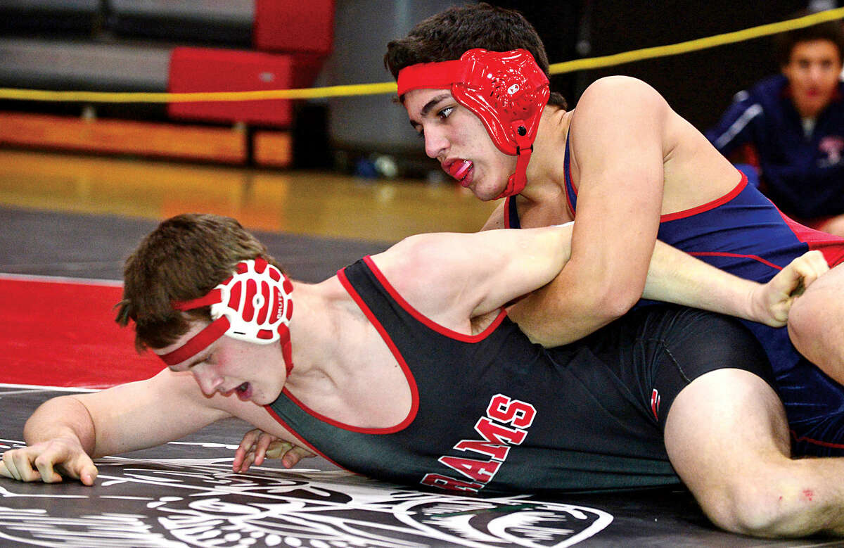 Hour photo / Erik Trautmann Local wrestlersJeff Capone of BMHS and Will Arlis of New Canaan compete at 182 in the FCIAC Championship meet at New Canaan High School Saturday.