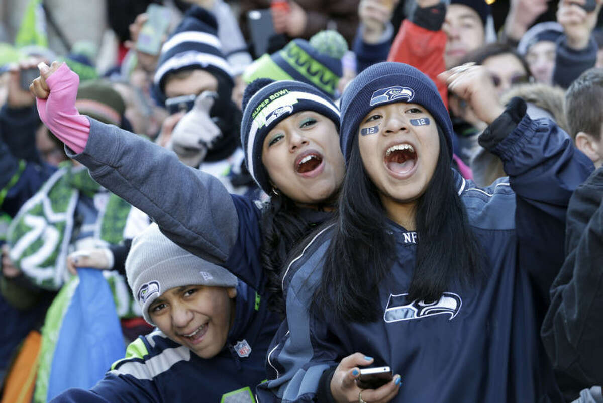 A Seattle Seahawks fan wearing a Russell Wilson jersey waves a