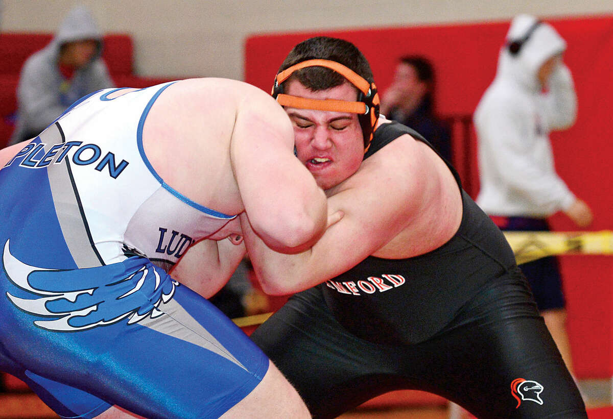 Hour photo / Erik Trautmann Local wrestlers compete in the FCIAC Championship meet at New Canaan High School Saturday.