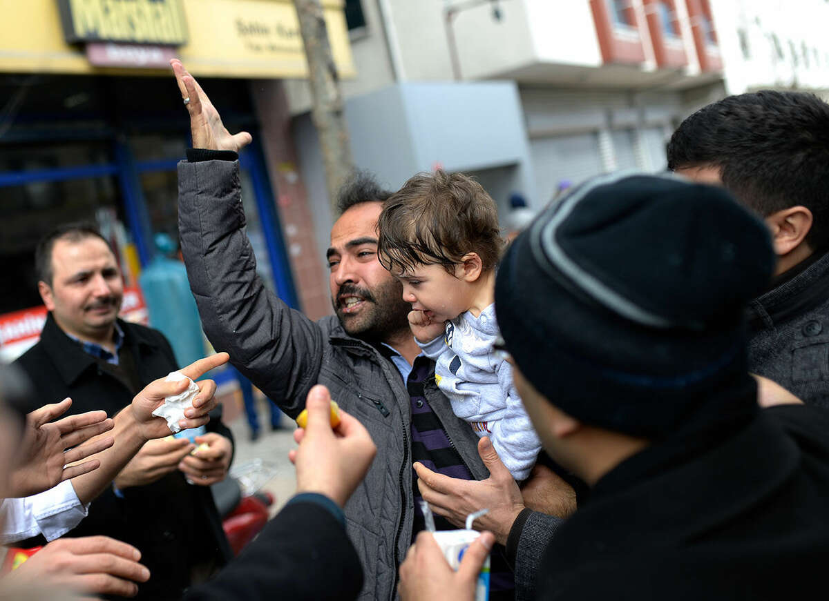 A man reacts as riot police use tear gas and water cannons to disperse people gathered in support outside the headquarters of Zaman newspaper in Istanbul, Saturday, March 5, 2016. Police have erected fences and are standing watch in front of the headquarters of Turkey's largest-circulation newspaper a day after it used tear gas and water cannons to storm the building and enforce a court-ordered seizure. The seizure of Zaman newspaper and its sister outlets Friday has escalated fears over media freedom in Turkey. (AP Photo/Akin Celiktas)