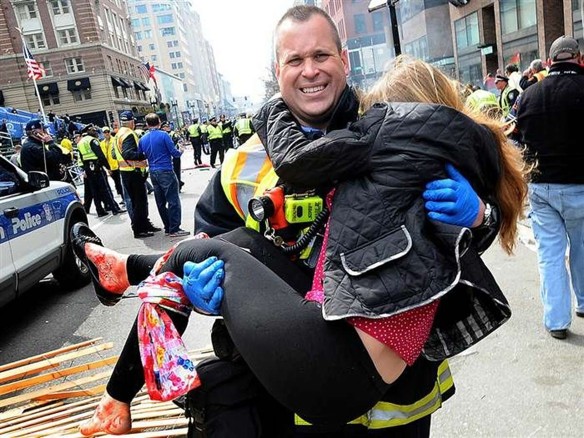Boston firefighter Jimmy Plourde carries injured Victoria McGrath away from the scene after a bombing near the finish line of the Boston Marathon in Boston. The FBI's investigation into the bombings at the Boston Marathon.