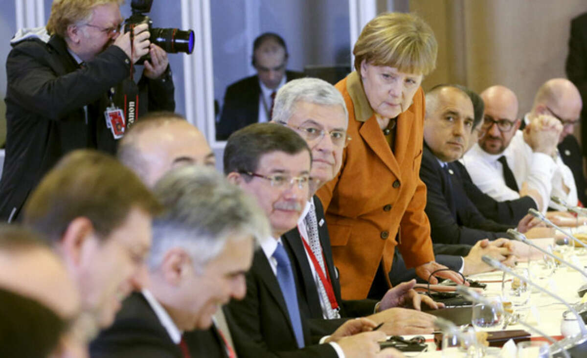 German Chancellor Angela Merkel, center, takes her seat during a lunch with other leaders at an EU summit in Brussels on Monday, March 7, 2016. European Union leaders arrived in Brussels Monday to press Turkey to do more to stop migrants entering Europe and to shore up support for Greece, where thousands of people are stranded. (Olivier Hoslet, Pool Photo via AP)