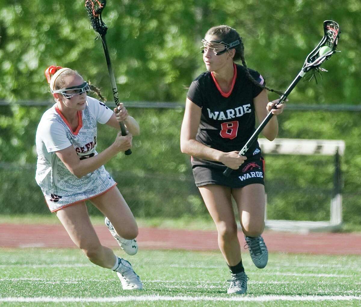 Ridgefield High School's Lucie Picard chases Fairfield Warde High School's Courtney Scheetz in a game played at Ridgefield. Friday, May 20, 2016