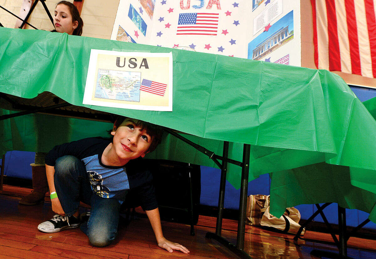 K.T. Murphy School students Athan Gzavaras and his sister Zoina Gzavaras man the table for the United States during the 6th annual Multiculturism Fair at K.T. Murphy School in Stamford Saturday. The fair featured interactive displays and food tastings from 19 different countries.