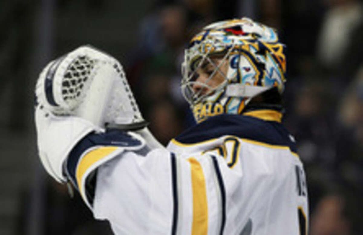 Buffalo Sabres goalie Ryan Miller checks his glove after giving up goal to the Colorado Avalanche in the second period of an NHL hockey game in Denver, Saturday, Feb. 1, 2014. (AP Photo/David Zalubowski)
