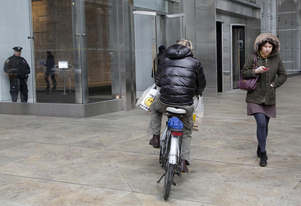 In this March 4, 2016 photo, a bicyclist rides on a sidewalk in New York. The city that pioneered "broken windows policing" is retooling its longtime strategy of cracking down hard on people who commit minor offenses, like public drinking, littering, riding a bicycle on the sidewalk or marijuana possession. (AP Photo/Mark Lennihan)