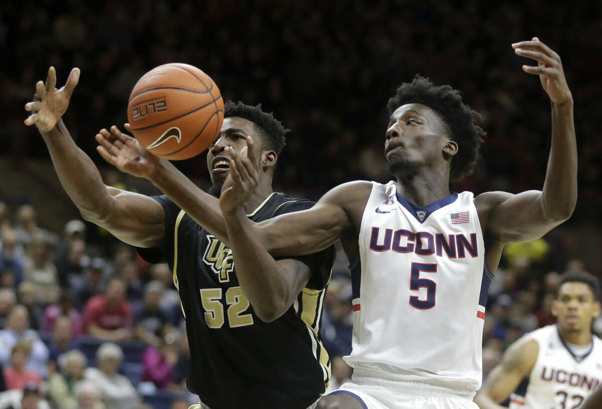 Central Florida’s Staphon Blair (52) vies for control of the ball with Connecticut's Daniel Hamilton (5) in the first half of an NCAA college basketball game Sunday, March 6, 2016, in Storrs, Conn. (AP Photo/Steven Senne)