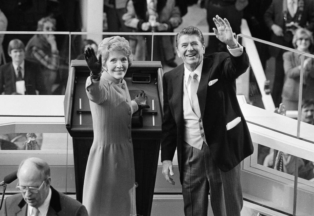 In this Jan. 20, 1981, file photo, President Ronald Reagan and first lady Nancy Reagan wave to onlookers at the Capitol building as they stand at the podium in Washington following the swearing in ceremony.