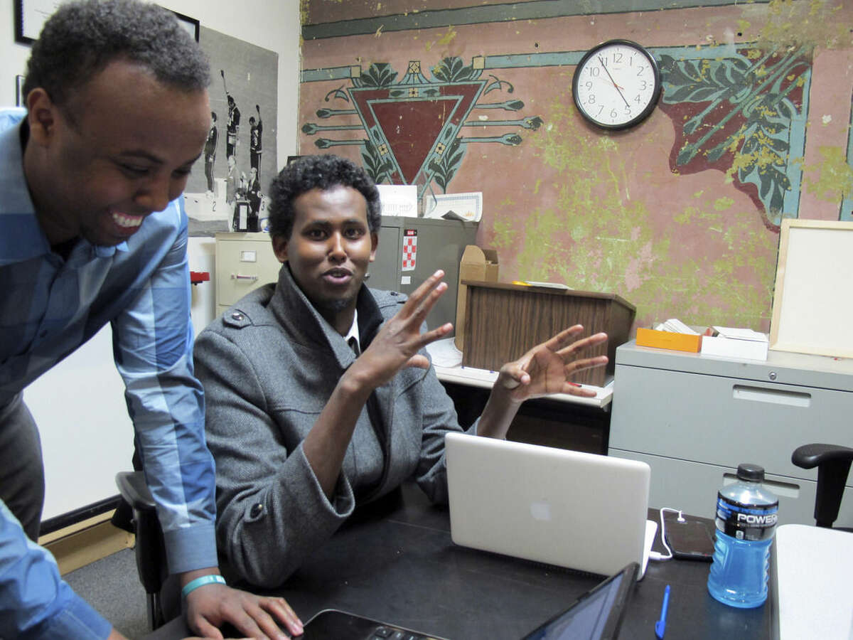 FILE - In this Thursday, Feb. 27, 2014 file photo, Mohamed Farah, left, executive director of Ka Joog, talks with Vice President Daud Mohamed in Minneapolis. U.S. Attorney Andy Luger will lead a delegation of local law enforcement and Somali community leaders, including Farah, to a meeting in Washington on Feb. 18, 2015. Farah said he plans to talk about of some the successes his youth group has had through its educational and arts programs. (AP Photo/Amy Forliti, File)