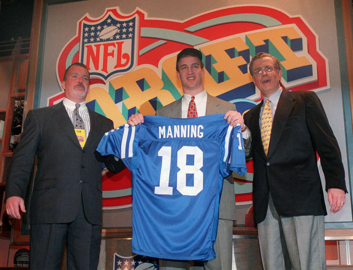FILE - In this April 18, 1998, file photo, Peyton Manning holds up an Indianapolis Colts jersey as he is flanked by Colts owner Jim Irsay, left, and NFL Commissioner Paul Tagliabue after being chosen as the No. 1 pick in the NFL Draft, in New York. A person with knowledge of the decision tells The Associated Press on Sunday, March 6, 2016, that Manning has informed the Denver Broncos he's going to retire. (AP Photo/Adam Nadel, File)