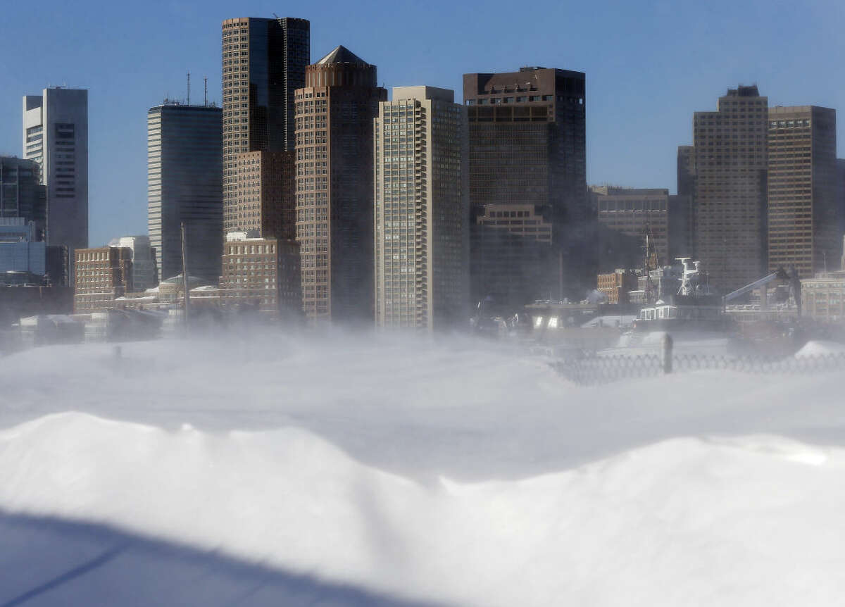 Blowing snow on the waterfront in the East Boston neighborhood of Boston partially obscures the skyline, Monday, Feb. 16, 2015. New England remained bitterly cold Monday after the region's fourth winter storm in a month blew through. (AP Photo/Michael Dwyer)
