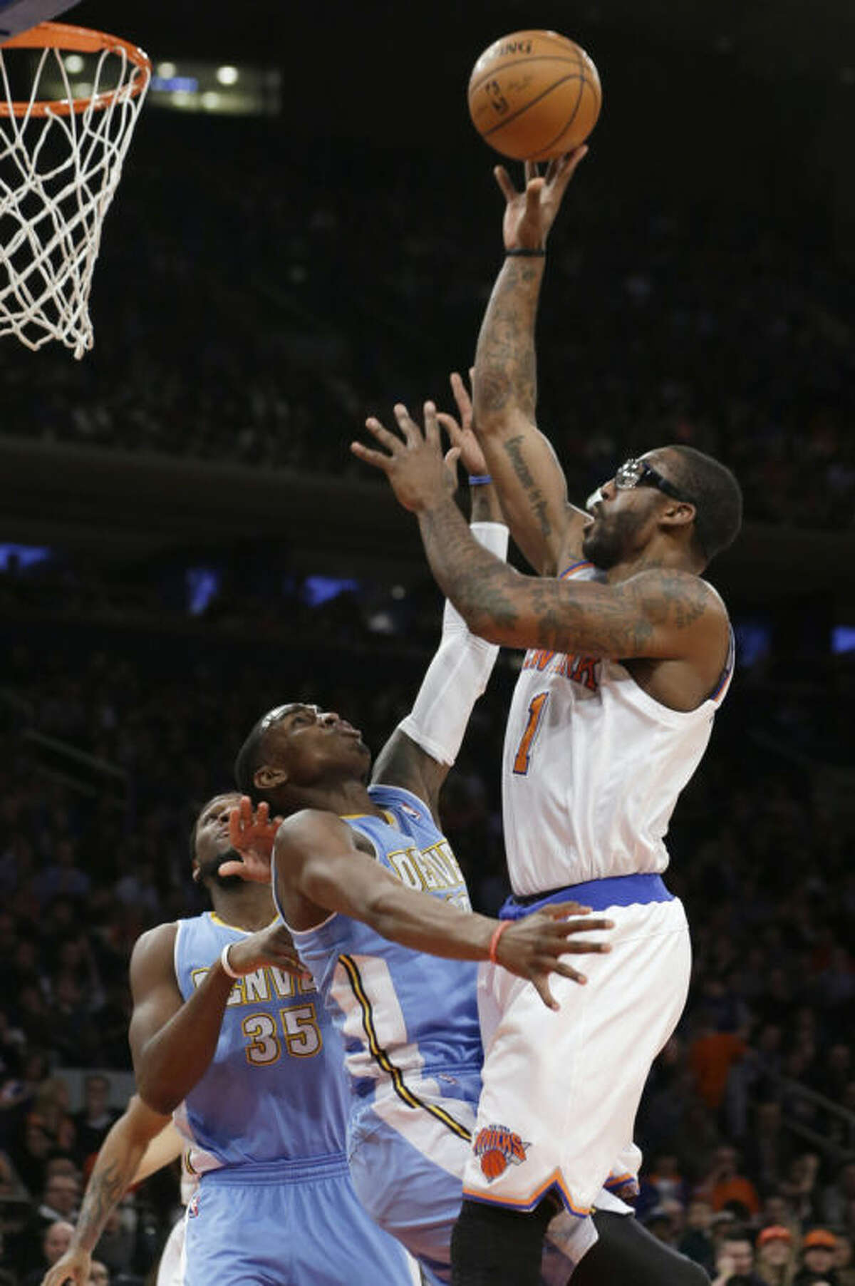 New York Knicks' Amare Stoudemire (1) shoots over Denver Nuggets' Quincy Miller (30) during the first half of an NBA basketball game Friday, Feb. 7, 2014, in New York. (AP Photo/Frank Franklin II)