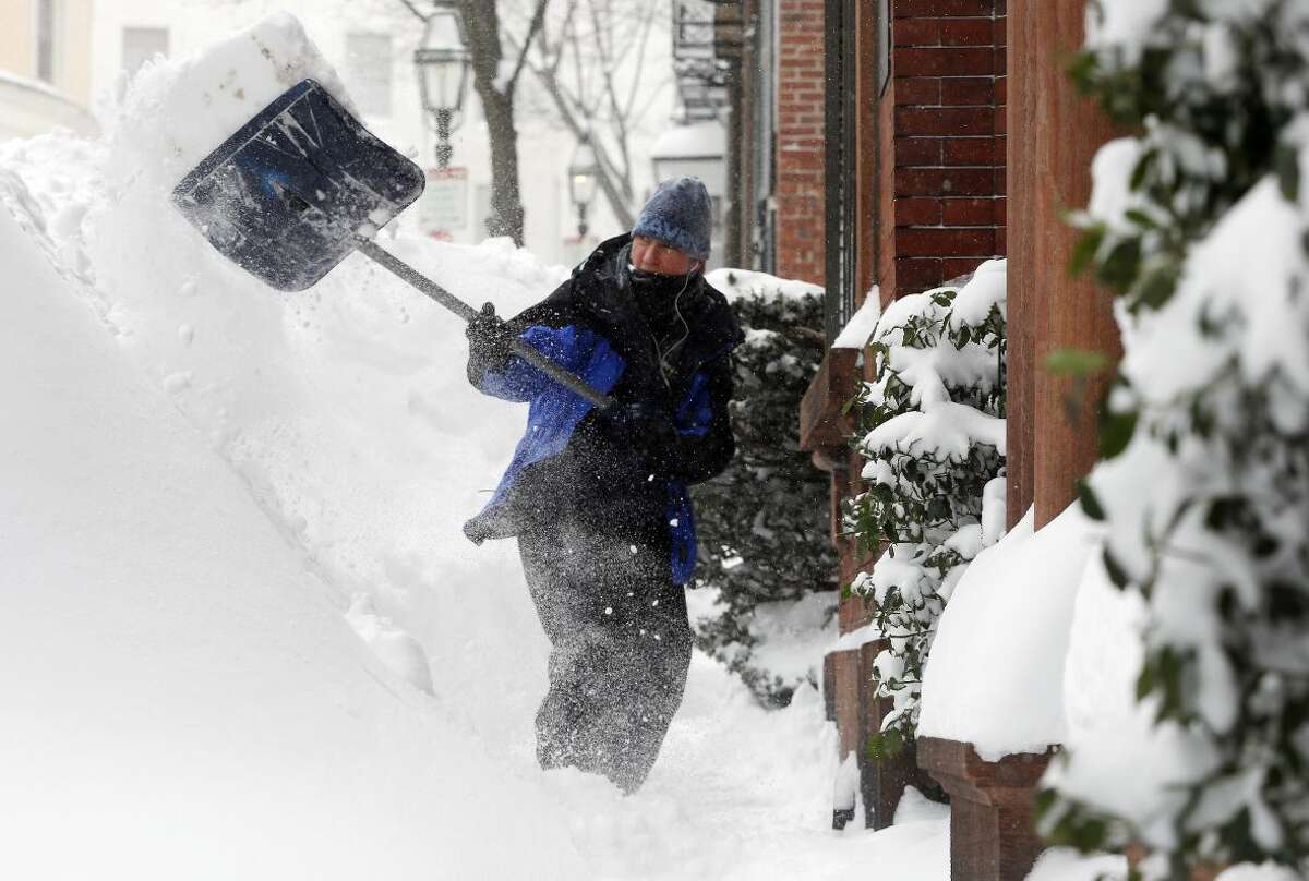 Judith Hanson shovels snow on Beacon Hill in Boston, Sunday, Feb. 15, 2015. A storm brought a new round of wind-whipped snow to New England on Sunday, accompanied by near-whiteout conditions and lightning strikes in coastal areas as people contended with a fourth winter onslaught in less than a month. (AP Photo/Michael Dwyer)