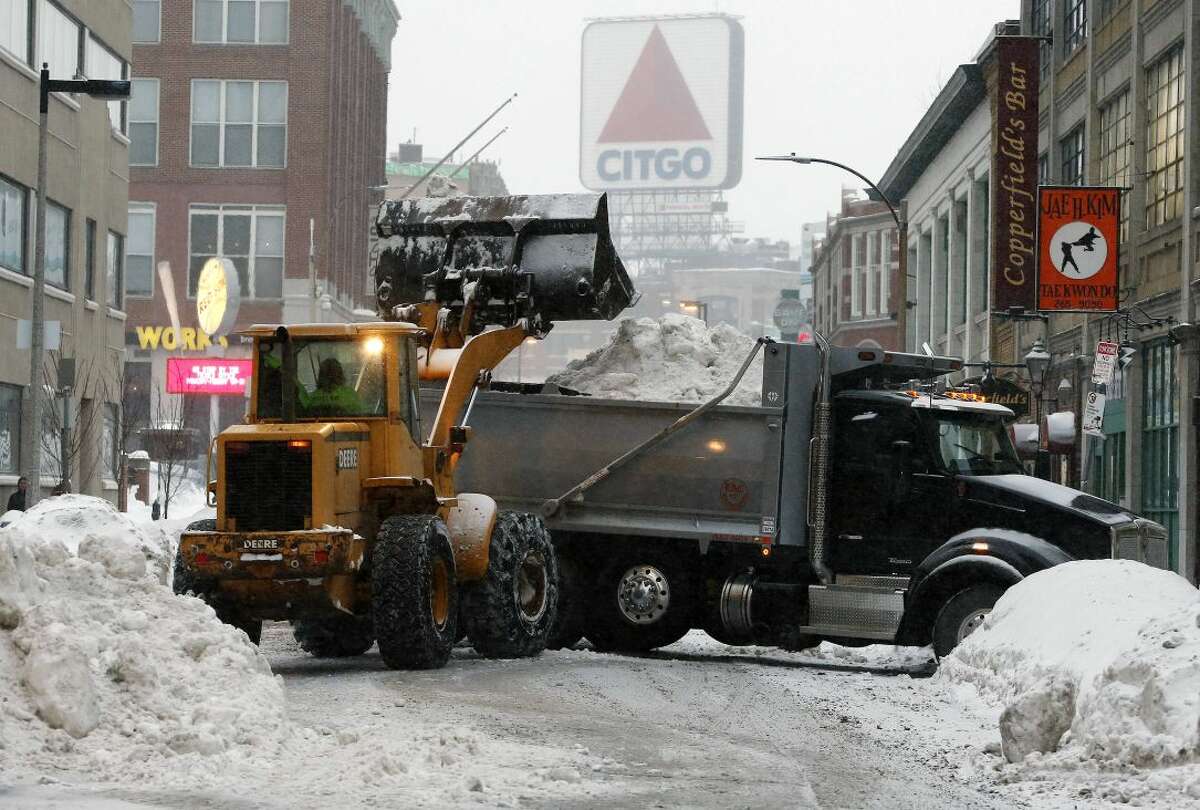 A crew from Connecticut clears snow from the street near Fenway Park in Boston, Saturday, Feb. 14, 2015. Crews from around the region have worked urgently to remove the massive amounts of snow that has clogged streets and triggered numerous roof collapses ahead of yet another winter storm due to arrive on Saturday. (AP Photo/Michael Dwyer)