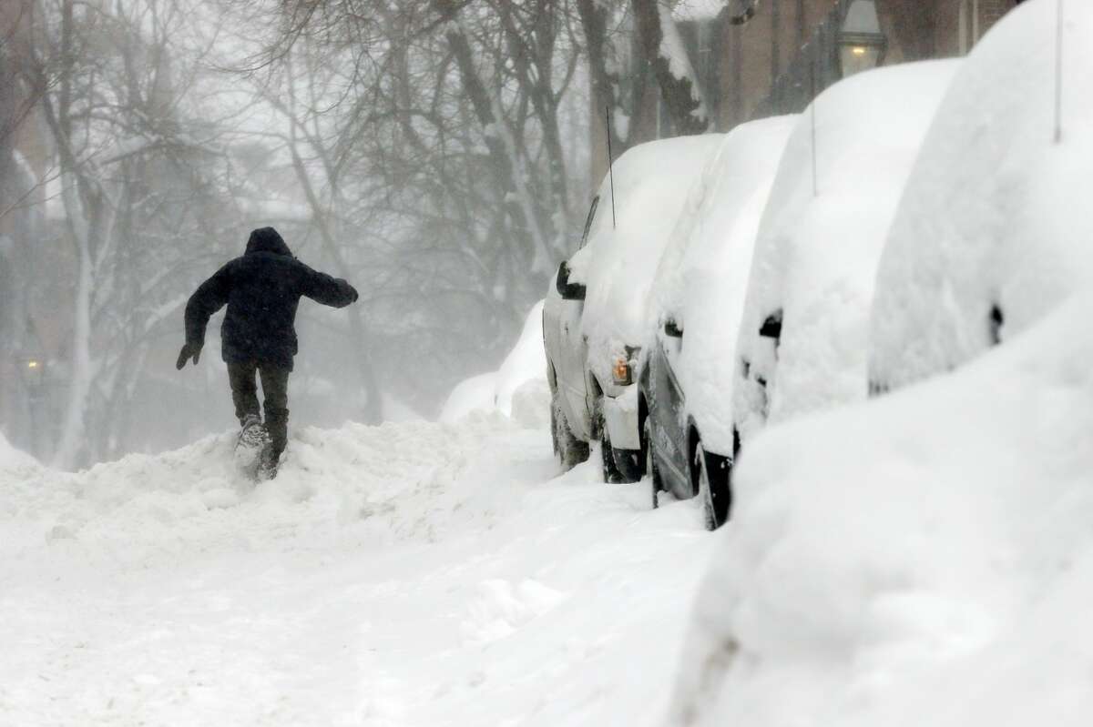 A man struggles through the snow on Beacon Hill in Boston, Sunday, Feb. 15, 2015. A storm brought a new round of wind-whipped snow to New England on Sunday, accompanied by near-whiteout conditions and lightning strikes in coastal areas as people contended with a fourth winter onslaught in less than a month. (AP Photo/Michael Dwyer)