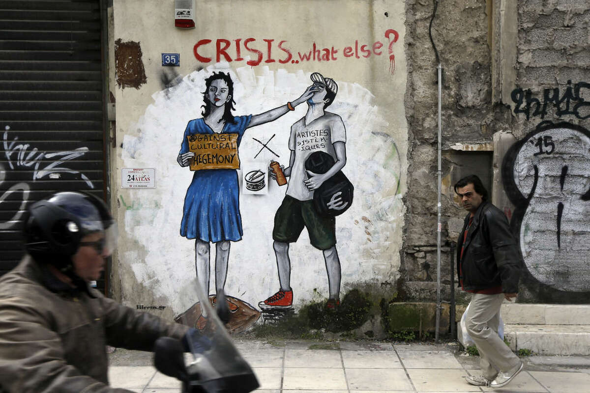A pedestrian passes anti-austerity graffiti in Athens, Monday, Feb. 16, 2015. Greece's radical left government and its European creditors are heading into new talks Monday on the debt-heavy country's stuttering bailout program, but expectations are low despite a fast-approaching deadline for some kind of deal. (AP Photo/Thanassis Stavrakis)