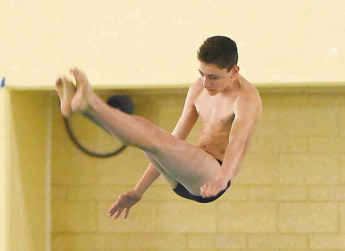 Hour photo/John Nash - Zach Cooper of Staples performs one of his dives during Wednesday's CIAC Class LL diving championship meet in Hamden.