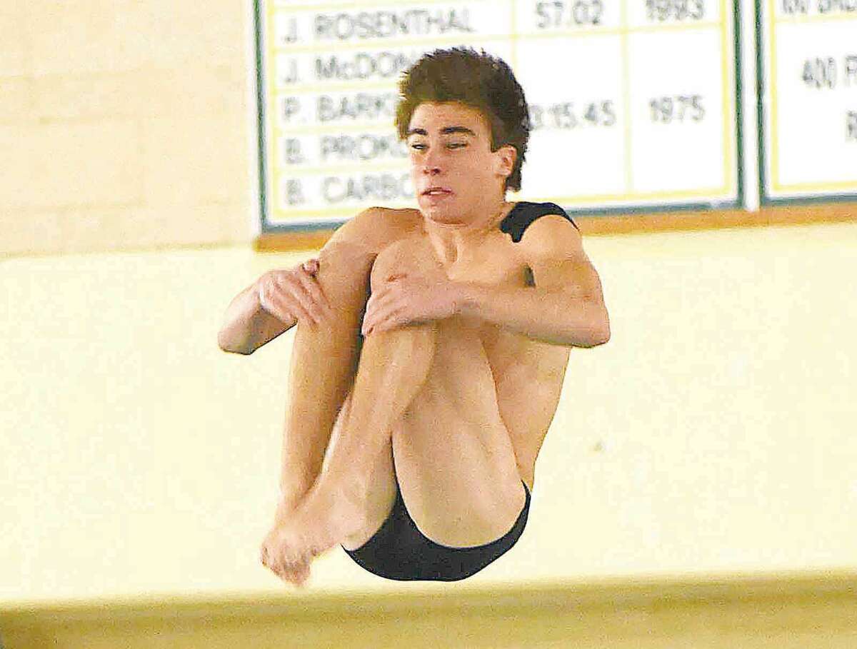 Hour photo/John Nash - Norwalk-McMahon co-op freshman diver Kevin Bradley tucks during a somersault during one of his 11 dives at Wednesday's CIAC Class LL diving championship meet at Hamden High School.