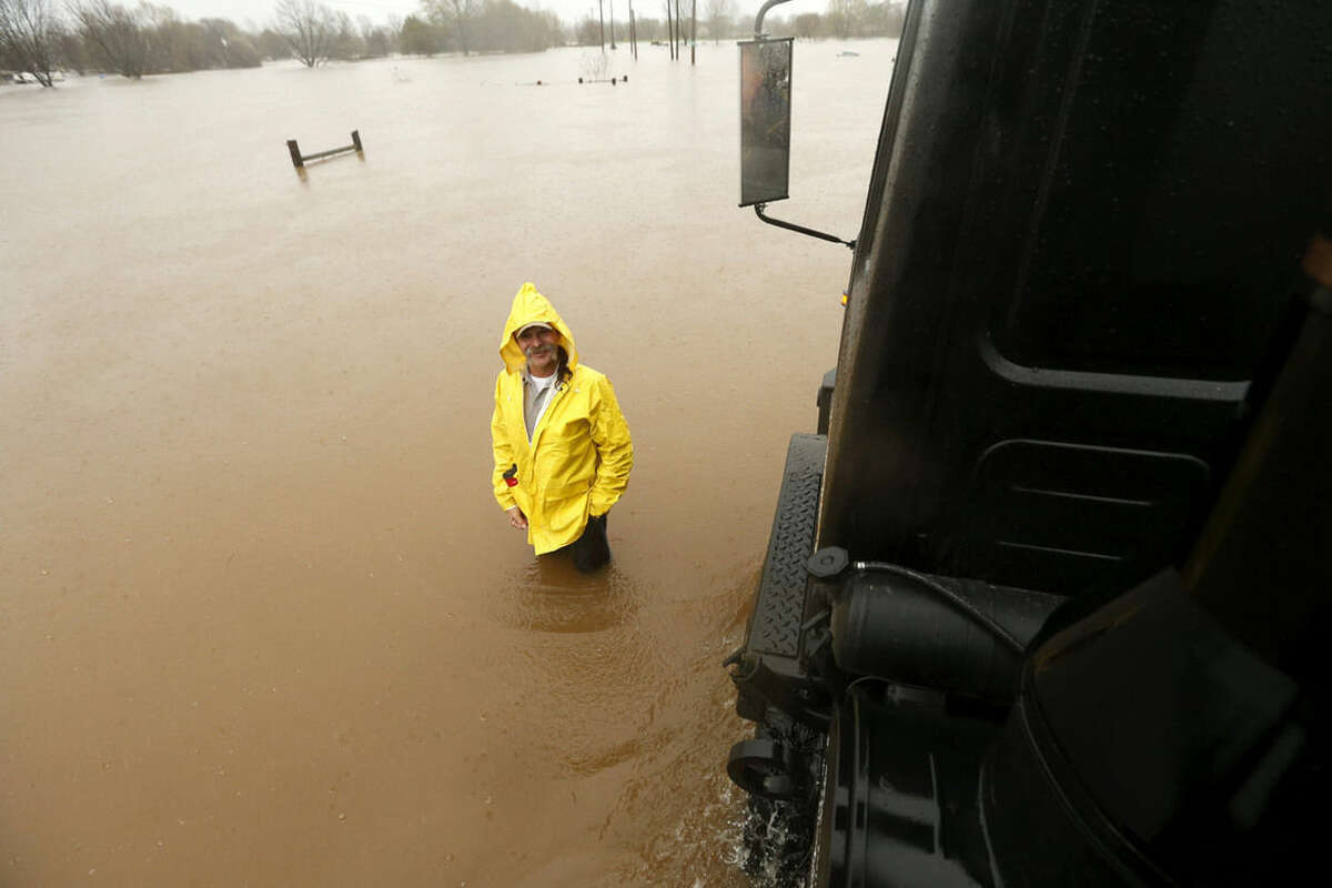 A man stands in rising floodwaters as a Bossier Parish Sheriff truck passes through rising floodwaters in Bossier Parish, La., Thursday, March 10, 2016. A second round of rain early Thursday hit an already inundated north Louisiana, where flooding in some places was up to the rooftops and in others submerged cars, stranded families and forced evacuations. (AP Photo/Gerald Herbert)