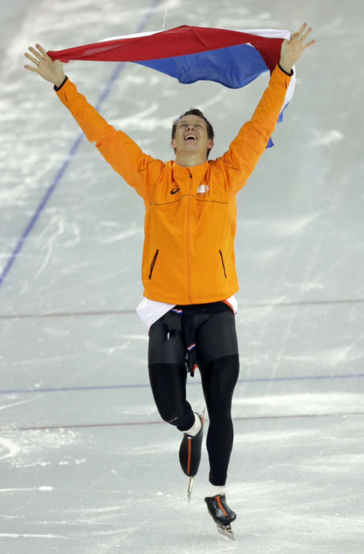Stefan Groothuis of the Netherlands holds his national flag and celebrates after winning the gold in the men's 1,000-meter speedskating race at the Adler Arena Skating Center at the 2014 Winter Olympics in Sochi, Russia, Wednesday, Feb. 12, 2014. (AP Photo/David J. Phillip )
