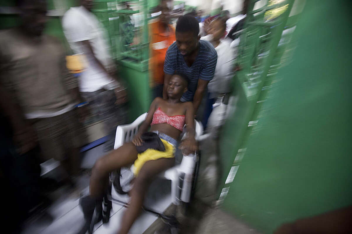 A reveler who was injured during carnival celebrations waits for treatment at the emergency room of the General Hospital in Port-au-Prince, Haiti, early Tuesday, Feb. 17, 2015. At least 20 people on a music group's packed Carnival float in the Haitian capital were killed Tuesday when they were electrocuted by a power line, officials said. The accident occurred as thousands of people filled the streets of downtown Port-au-Prince for the raucous annual celebration. People at the scene said someone on the float used a pole or stick to move a power line so the float could pass under it.( AP Photo/Dieu Nalio Chery)