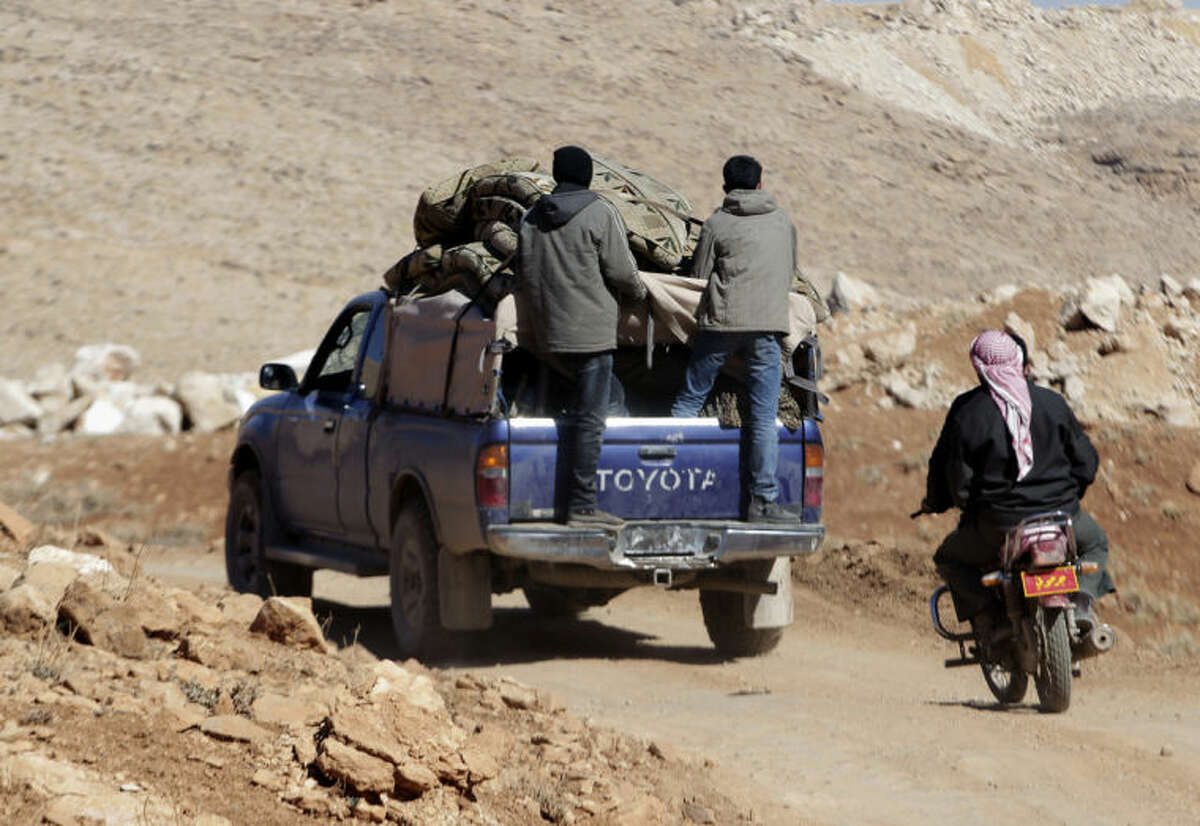 Syrian citizens ride in the back of a truck with their belongings after fleeing Yabroud, the last rebel stronghold in Syria's mountainous Qalamoun region, as they drive towards the Lebanese-Syrian border town of Arsal in eastern Lebanon, Thursday, Feb. 13, 2014. Syrian troops pounded Thursday the town of Yabroud the last rebel stronghold in Syria's mountainous Qalamoun region, forcing hundreds to flee into the nearby Lebanese town of Arsal. Backed by Lebanon's Hezbollah fighters, the Syrian army has been on a crushing offensive in the region since early December. (AP Photo/Bilal Hussein)