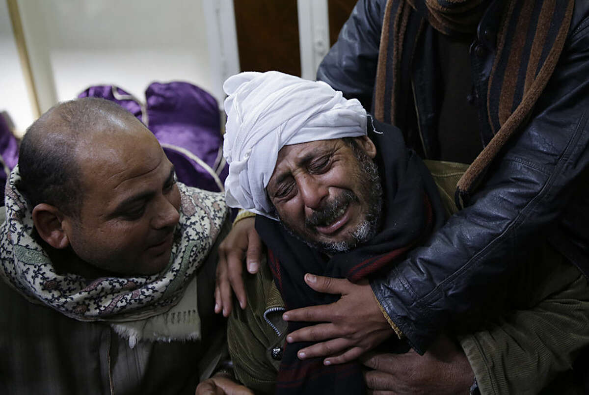 A man is comforted by others as he mourns over Egyptian Coptic Christians who were captured in Libya and killed by militants affiliated with the Islamic State group, outside of the Virgin Mary church in the village of el-Aour, near Minya, 220 kilometers (135 miles) south of Cairo, Egypt, Monday, Feb. 16, 2015. Egyptian warplanes struck Islamic State targets in Libya on Monday in swift retribution for the extremists' beheading of a group of Egyptian Christian hostages on a beach, shown in a grisly online video released hours earlier. (AP Photo/Hassan Ammar)