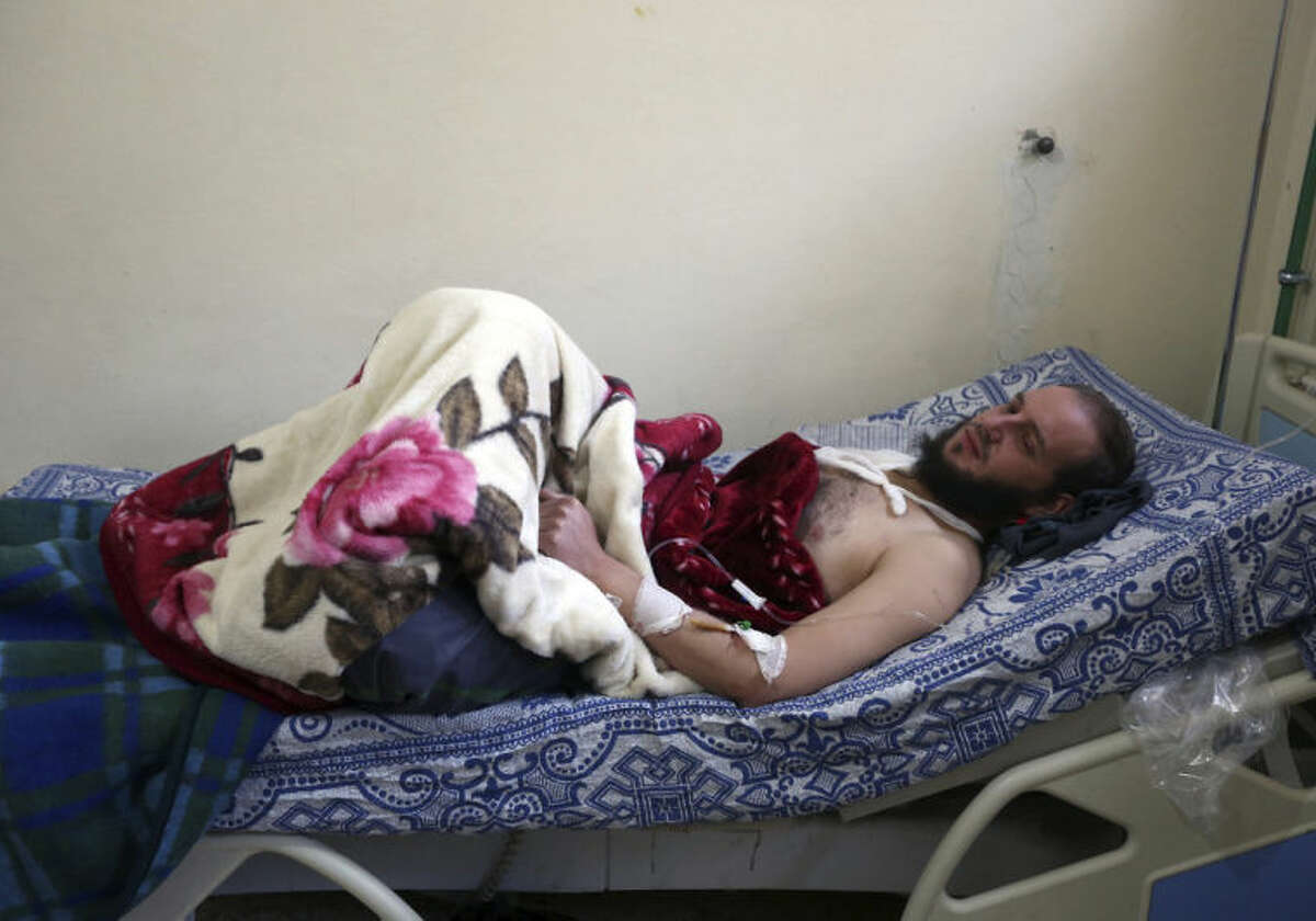 Syrian Abu Usama, 29, who was wounded in Yabroud as a result of Syrian government shelling, rests in a field hospital at the Lebanese-Syrian border town of Arsal in eastern Lebanon, Thursday, Feb. 13, 2014. Syrian troops pounded Thursday the town of Yabroud the last rebel stronghold in Syria's mountainous Qalamoun region, forcing hundreds to flee into the nearby Lebanese town of Arsal. Backed by Lebanon's Hezbollah fighters, the Syrian army has been on a crushing offensive in the region since early December. (AP Photo/Bilal Hussein)