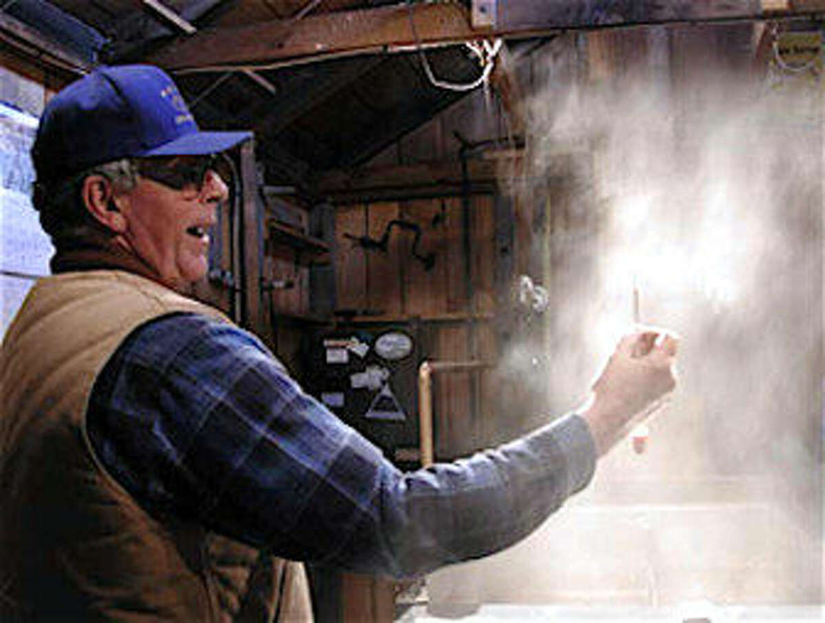 COURTESY OF RON WENZEL Ron Wenzel of the Wenzel Sugarhouse in Hebron tests the maple sap as it concentrates into syrup.