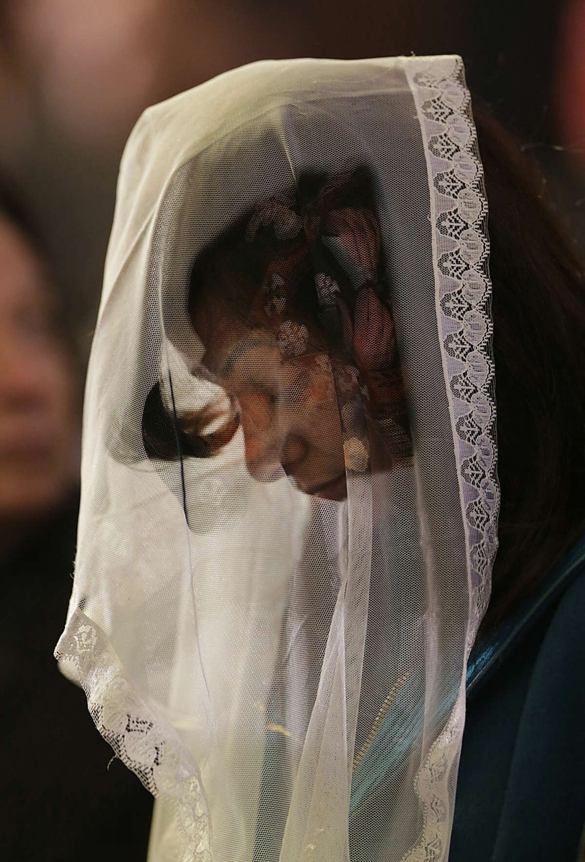 A woman prays during a mass lead by Pope Tawadros II, the 118th pope of the Coptic Church of Egypt, for the Egyptian Christians who were killed in Libya, at St. Mark's Cathedral in Cairo, Egypt, Tuesday, Feb. 17, 2015. An Islamic State video released on 15 February claimed to show the extremist group beheading 21 Egyptian Christians abducted in Libya more than a month ago. The Egyptian army responded on Feb. 16 by an airstrike against the militants targeting bases and weapons storage facilities in Libya. (AP Photo/Amr Nabil)