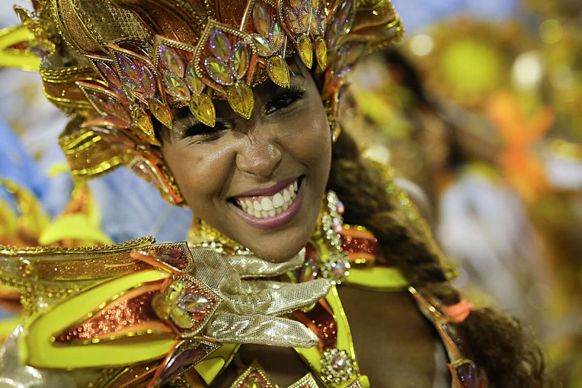 A performer from the Portela samba school smiles during the Carnival parade at the Sambadrome in Rio de Janeiro, Brazil, Monday, Feb. 16, 2015. (AP Photo/Felipe Dana)