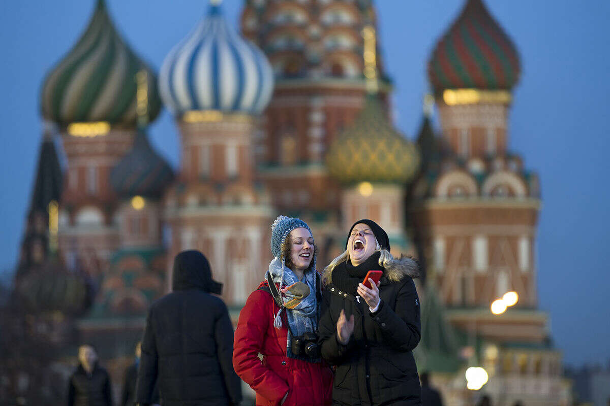 Tourists take a selfie in front of St. Basil Cathedral in Red Square in Moscow, Russia, Thursday, March 10, 2016. (AP Photo/Alexander Zemlianichenko)