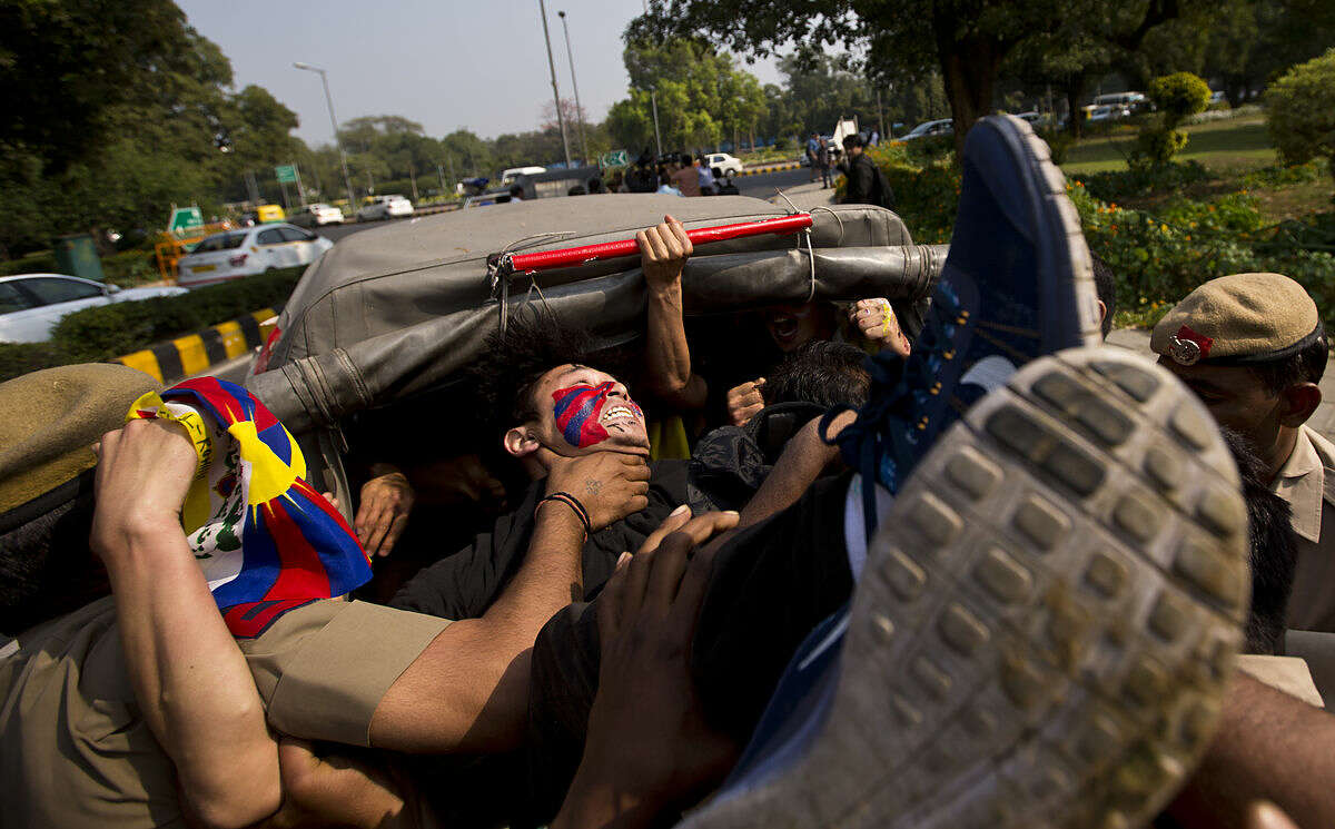 Tibetan exiles shouting anti China slogans outside the Chinese embassy are put in a police car as they protest to mark the 57th anniversary of the March 10, 1959, Tibetan Uprising Day, in New Delhi, India, Thursday, March 10, 2016. (AP Photo/Saurabh Das)