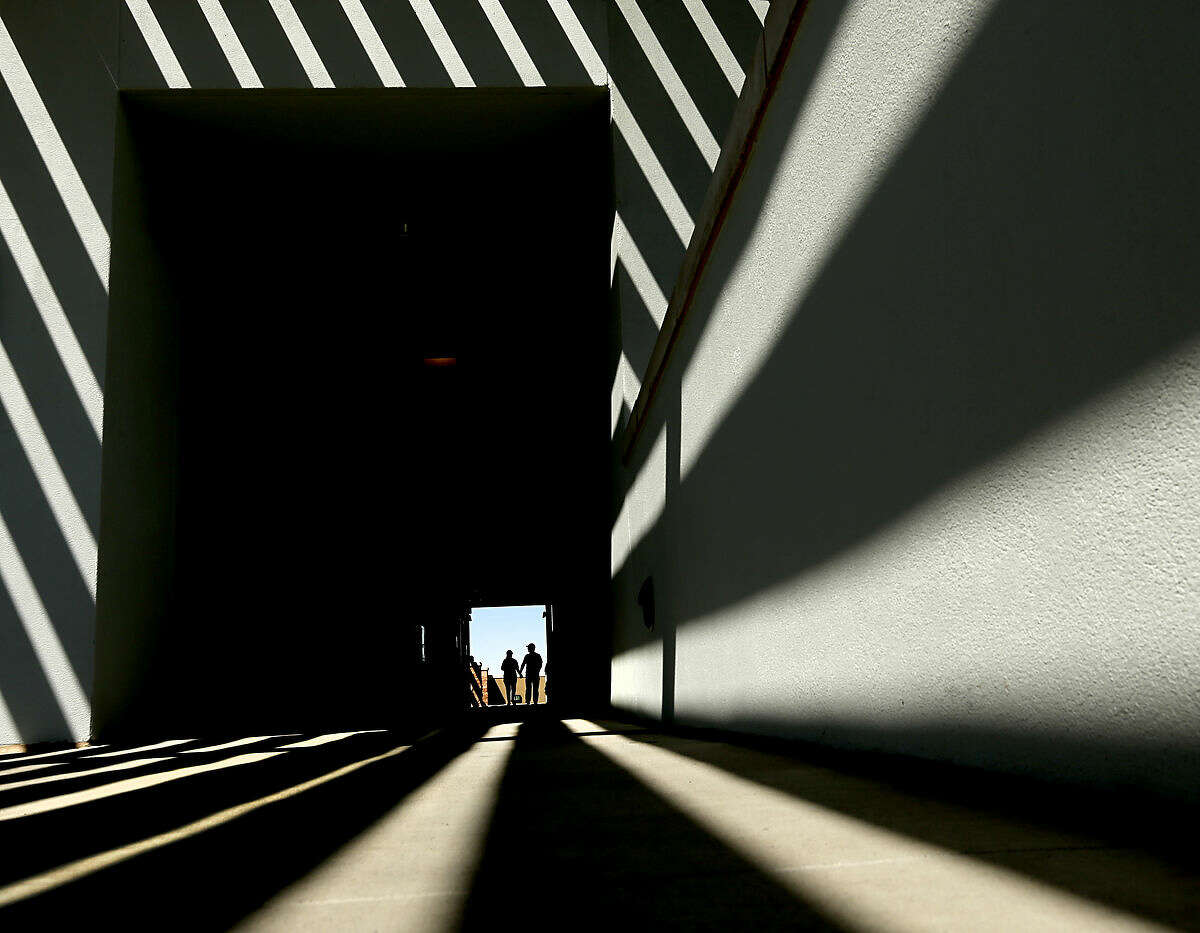 People walk through a concourse at Peoria Sports Complex before a spring training baseball game between the Seattle Mariners and the Chicago Cubs Thursday, March 10, 2016, in Peoria, Ariz. (AP Photo/Charlie Riedel)