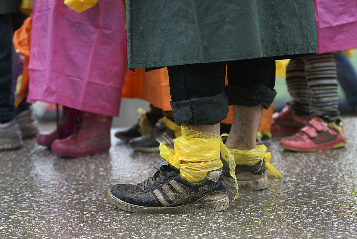 A man wears plastic sheets wrapped around his feet as mud protection while waiting for food handouts during a rainfall at the northern Greek border station of Idomeni, Thursday, March 10, 2016. After nearly three days of rain, conditions in the refugee camp on the Greek-Macedonian where about 14,000 people are stranded have deteriorated significantly, with many of its residents struggling to re-pitch their small camping tents in slightly drier patches. (AP Photo/Vadim Ghirda)