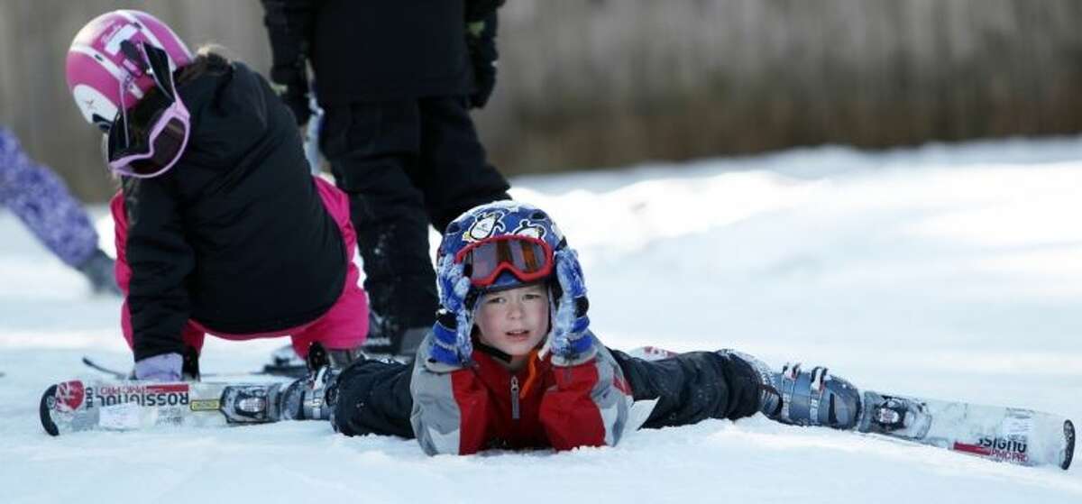 In this photo taken Thursday Jan. 30, 2014 a young skier is seen after falling in the terrain-based mini-pipe at Cranmore Mountain ski area in North Conway, N.H. The ski area is one of a few in the country that has started using terrain-based lessons to teach new skiers how to ski. (AP Photo/Jim Cole)