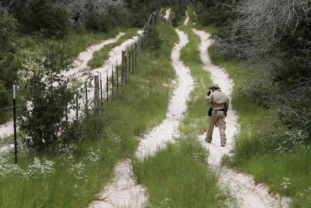 FILE- In this Sept. 5, 2014, file photo, a U.S. Customs and Border Protection Air and Marine agent looks for signs along trail while on patrol near the Texas-Mexico border near McAllen, Texas. A federal judge temporarily blocked President Barack Obama’s executive action on immigration Monday, Feb. 16, 2015, giving a coalition of 26 states time to pursue a lawsuit that aims to permanently stop the orders. (AP Photo/Eric Gay, File)