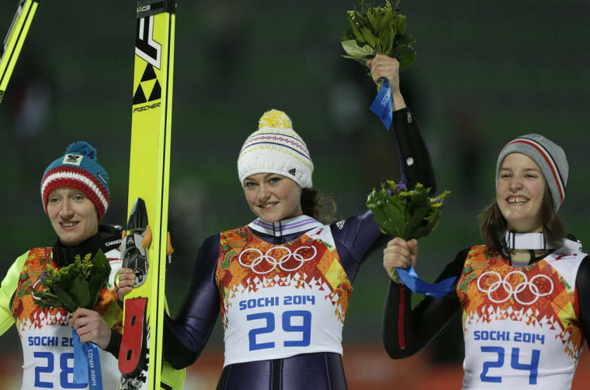 Germany's gold medal winner Carina Vogt is flanked by Austria's silver medal winner Daniela Iraschko-Stolz, left, and France's bronze medal winner Coline Mattel after the flower ceremony of the women's normal hill ski jumping final at the 2014 Winter Olympics, Tuesday, Feb. 11, 2014, in Krasnaya Polyana, Russia.(AP Photo/Matthias Schrader)