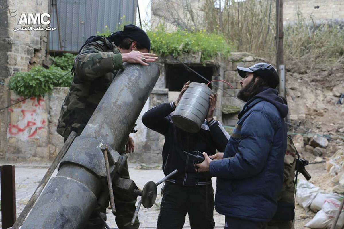 This photo provided on Sunday Feb. 15, 2015 by the Syrian anti-government activist group Aleppo Media Center (AMC), which has been authenticated based on its contents and other AP reporting, shows Syrian rebels preparing to fire locally made shells against the Syrian government forces, in Aleppo, Syria. Activists say Syrian rebels have regained much of an area north of the city of Aleppo that they lost to government troops in fierce fighting the previous day. The clashes have left more than 100 dead on both sides. (AP Photo/Aleppo Media Center, AMC)