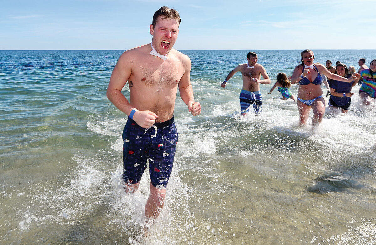 Hour photo / Erik Trautmann Jake DeLuca exits the water during the 2016 Westport Penguin Plunge at Compo Beach Saturday to benefit The Special Olympics.