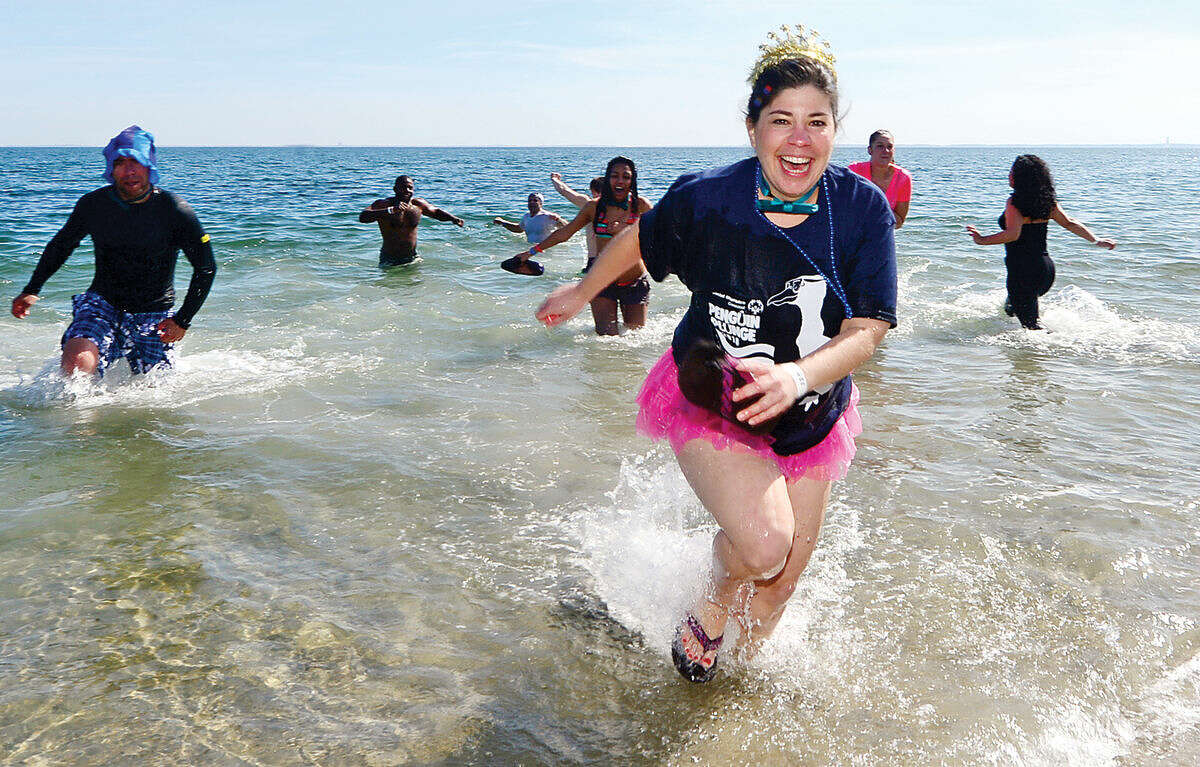 Hour photo / Erik Trautmann Westport resident Lauren Fitch exit the water during the 2016 Westport Penguin Plunge at Compo Beach Saturday to benefit The Special Olympics.