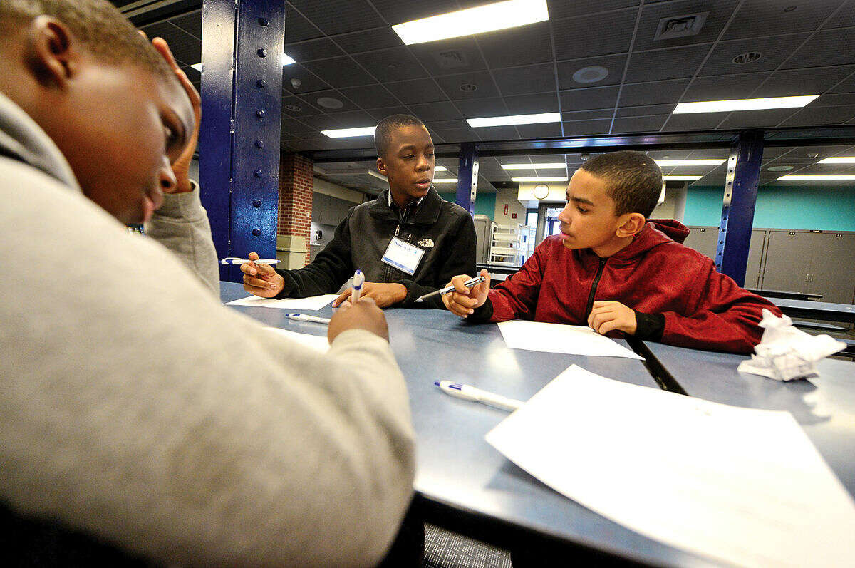 Hour photo / Erik Trautmann Children from the Norwalk Housing Authority after school programs including Sean Paul Joseph, Joshua Davis and George Dacruz work on their resumes while attending the Careers on Fleek event at the Maritime Aquarium Friday evening. The event provided middle school students with help with their career paths by playing games focusing on public speaking, personal finance, resume building and career opportunities and how to successfully join the work force.