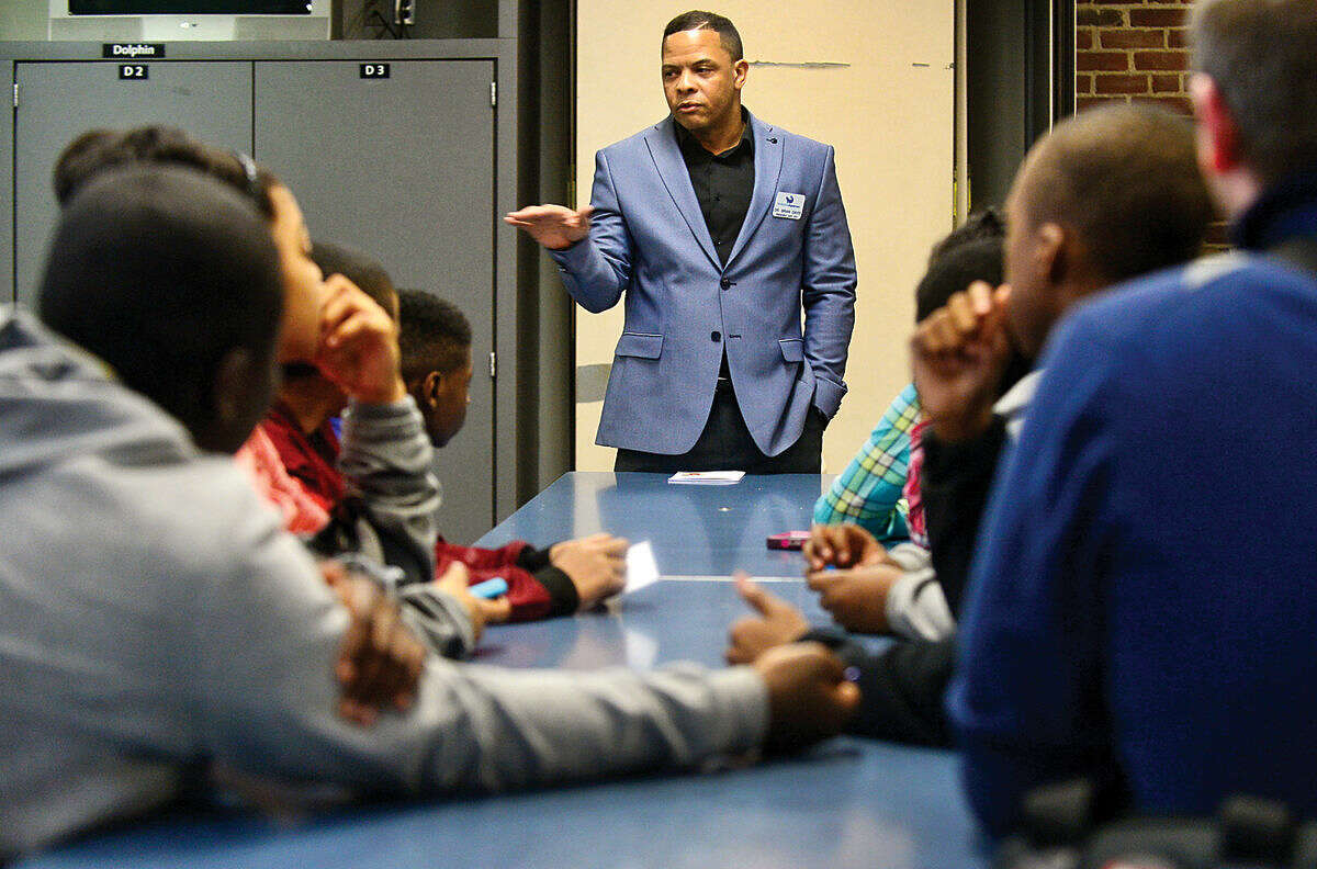 Hour photo / Erik Trautmann Maritime Aquarium president Dr. Brian Davis greets children from the Norwalk Housing Authority after school programs who attended the Careers on Fleek event at the Maritime Aquarium Friday evening. The event provided middle school students with help with their career paths by playing games focusing on public speaking, personal finance, resume building and career opportunities and how to successfully join the work force.