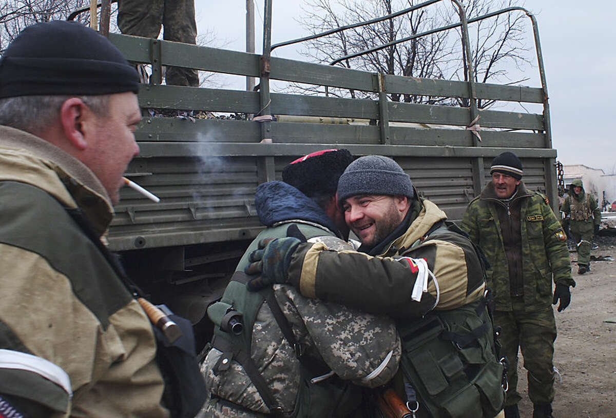 A pro-Russian rebel cossack, second left, hugs another rebel in Debaltseve, eastern Ukraine, Thursday, Feb. 19, 2015. After weeks of relentless fighting, the embattled Ukrainian rail hub of Debaltseve fell Wednesday to Russia-backed separatists, who hoisted a flag in triumph over the town. The Ukrainian president confirmed that he had ordered troops to pull out and the rebels reported taking hundreds of soldiers captive. (AP Photo/ Peter Leonard)
