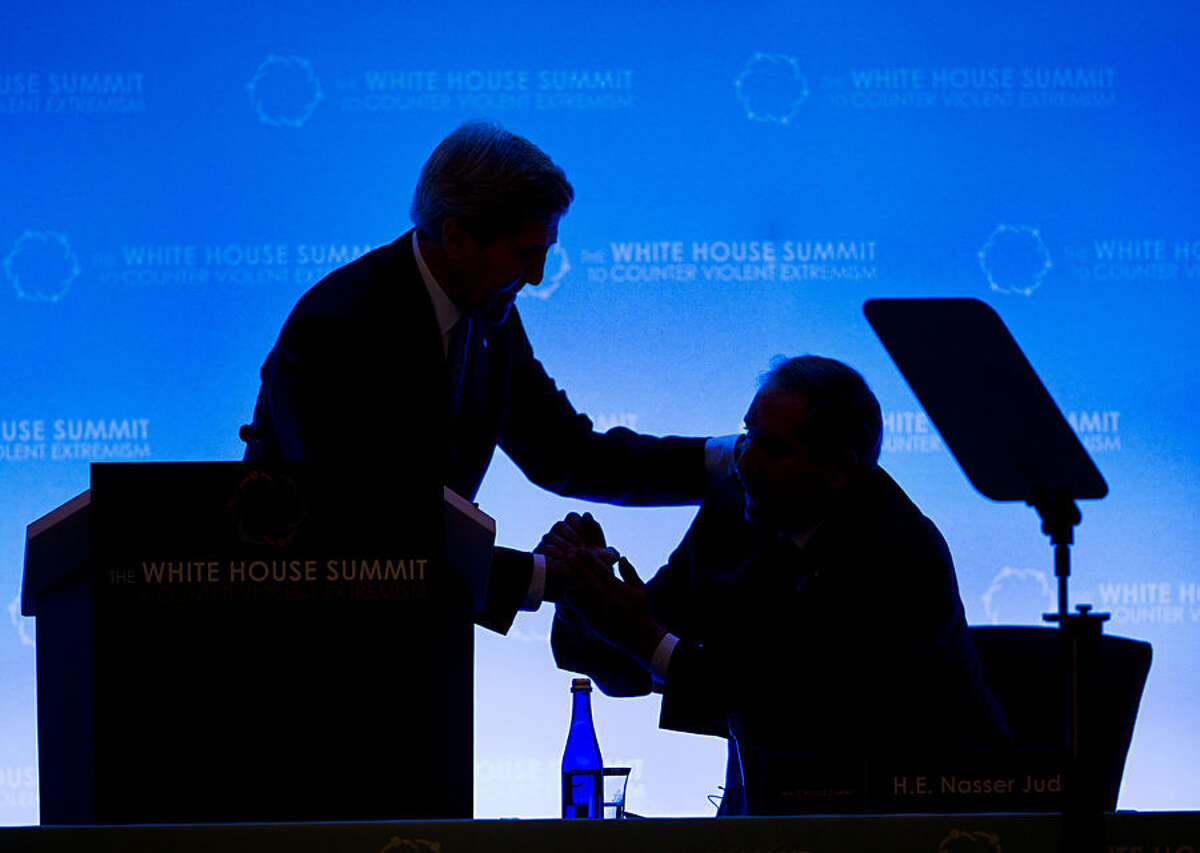 Secretary of State John Kerry, left, greets Jordan's Foreign Affairs Minister Nasser Judeh, right, as they are silhouetted on stage at the opening of the Countering Violent Extremism (CVE) Summit, Thursday, Feb. 19, 2015, at the State Department in Washington. The White House is conveying a three-day summit to bring together local, federal, and international leaders to discuss steps the US and its partners can take to develop community-oriented approaches to counter extremist ideologies that radicalize, recruit and incite to violence. (AP Photo/Pablo Martinez Monsivais)