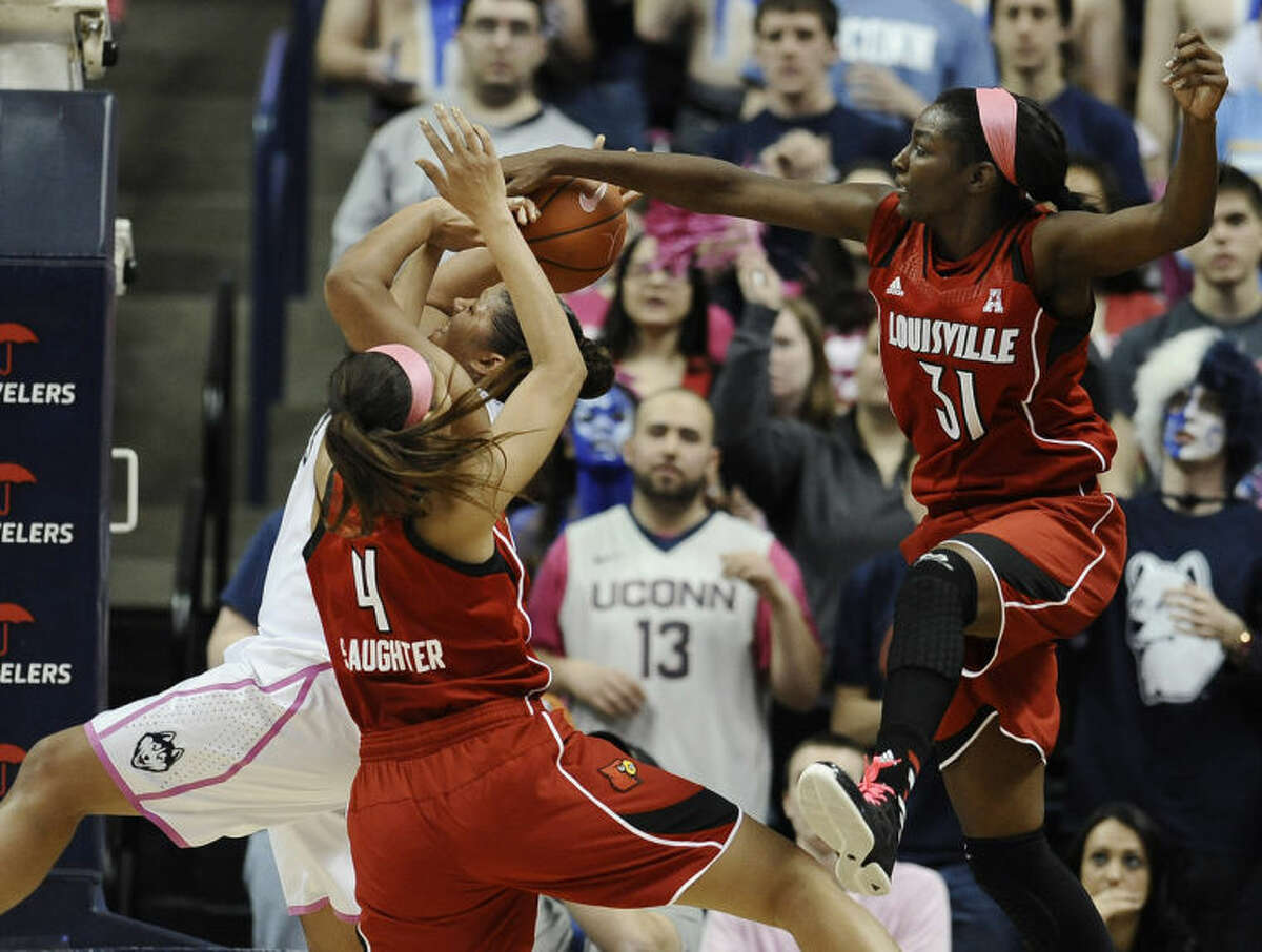 Louisville's Antonita Slaughter (4) and Asia Taylor (31) reach over Connecticut's Kaleena Mosqueda-Lewis who shoots during the first half of an NCAA college basketball game on Sunday, Feb. 9, 2014, in Storrs, Conn. Mosqueda-Lewis hit the floor on the play, injuring her left elbow. (AP Photo/Jessica Hill)