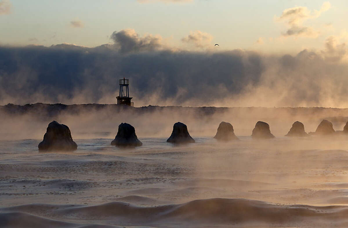 The sun rises above Lake Michigan as ice forms along the shore, Thursday, Feb. 19, 2015, in Chicago. Temperatures have dipped to as low as -13 in parts of Illinois with wind chills forecast to fall to between 20 and 30 degrees below zero. (AP Photo/Kiichiro Sato)