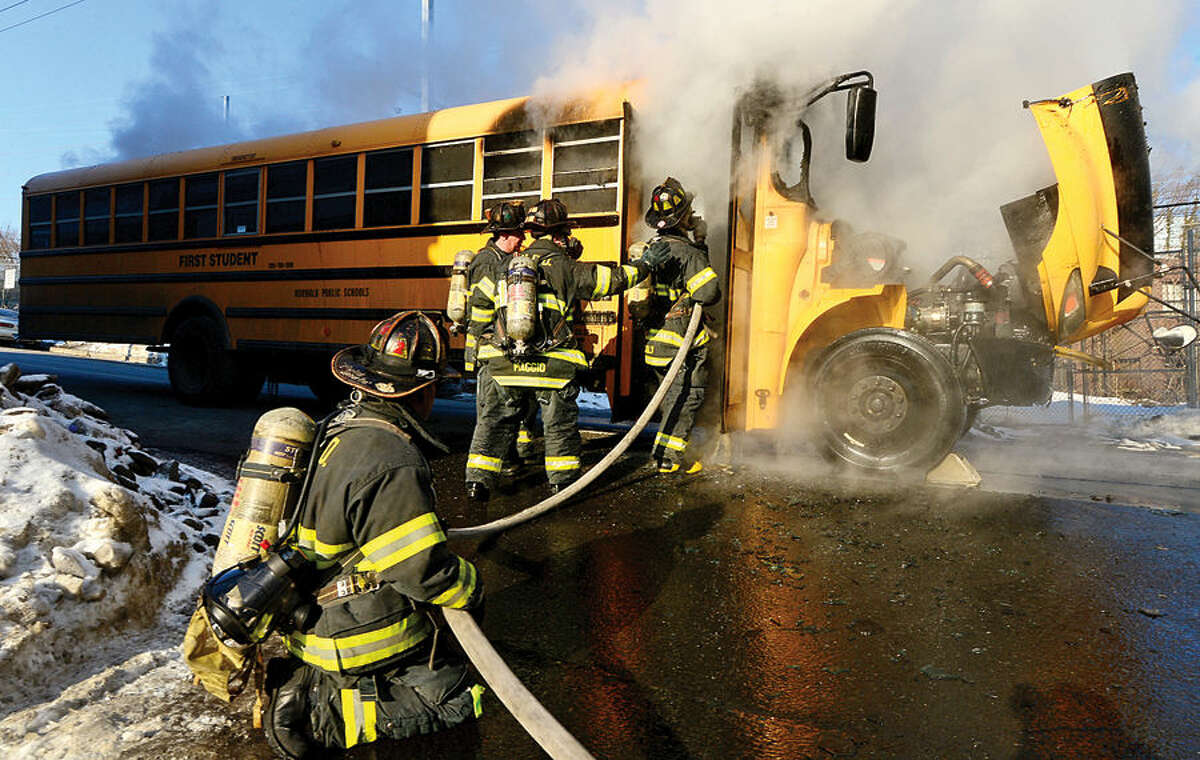 Hour photo / Erik Trautmann Norwalk firefihgters respond to a school bus fire at the corner of Lexiton and Ely Avenues Thursday morning. All students and the bus driver evacuated safely.
